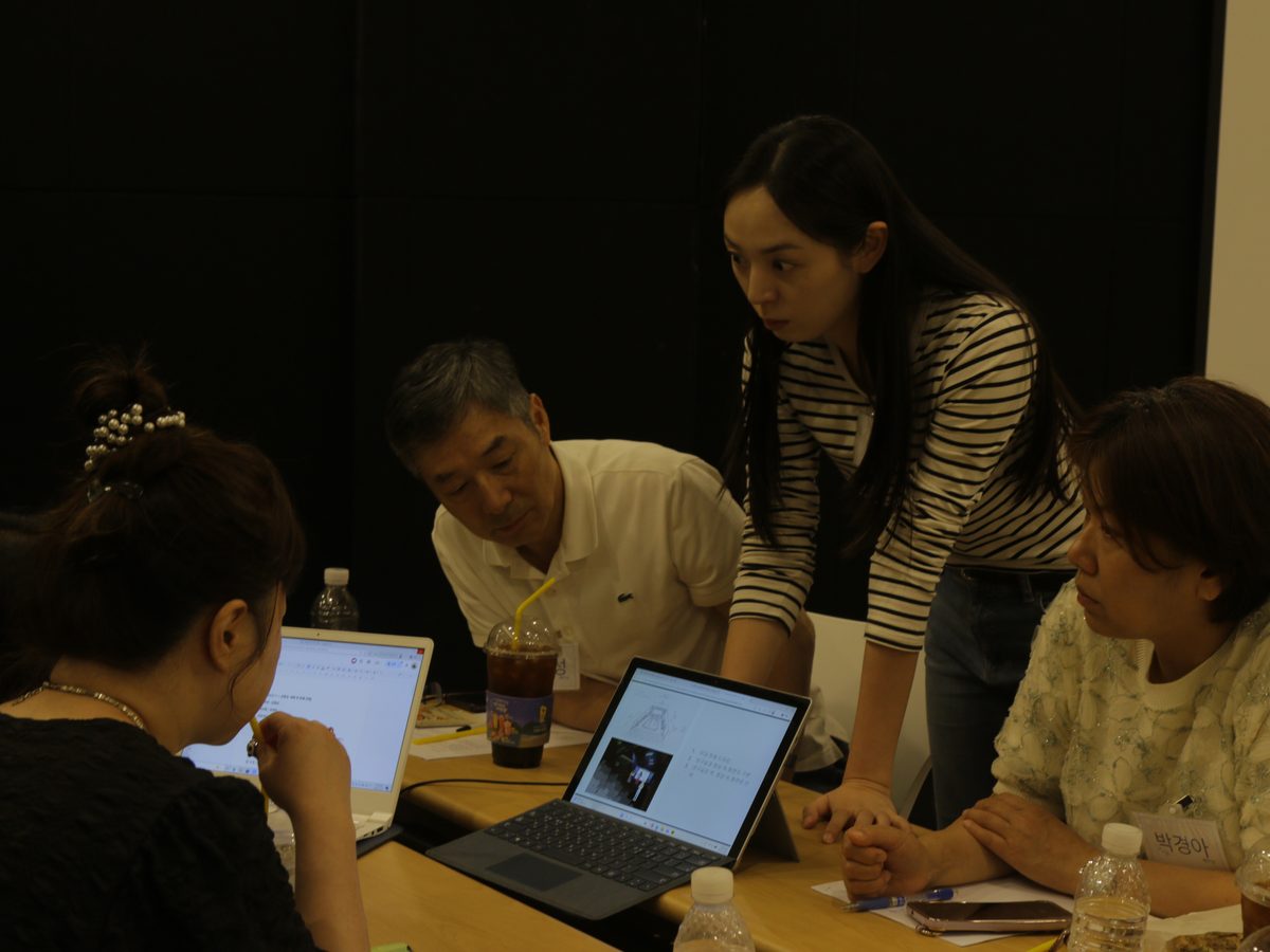 디렉터가 참여자들과 노트북으로 AI 대본을 함께 살펴보는 모습